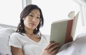 Woman reading book in bed